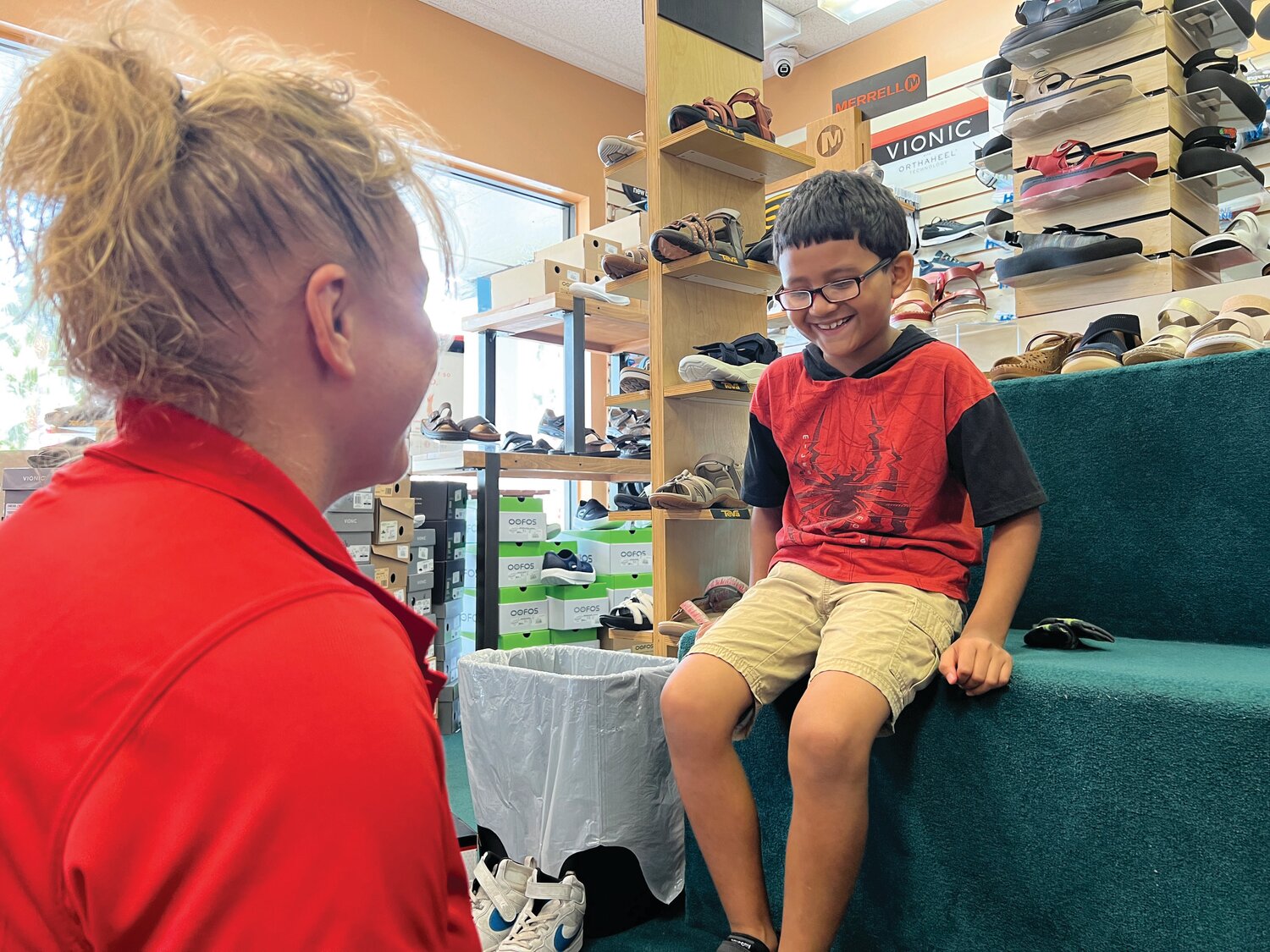 Snyderman Shoes Manager Becky Joyce, left, helps a Guadalupe Center student try on new shoes through a longstanding partnership with Laces of Love.